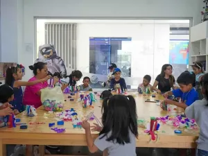 Niñas y niños realizan actividades creativas en un espacio de divulgación científica