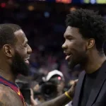 LeBron James conversa con Joel Embiid durante un partido entre Cavaliers y 76ers en Philadelphia