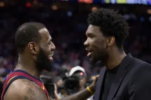LeBron James conversa con Joel Embiid durante un partido entre Cavaliers y 76ers en Philadelphia