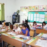 Estudiantes trabajan en un salón de clases