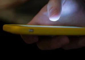 Persona utiliza un telefono celular, imagen de referencia sobre comunicaciones y seguimiento de noticias