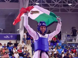 Taekwondoína mexicana celebra con la bandera nacional