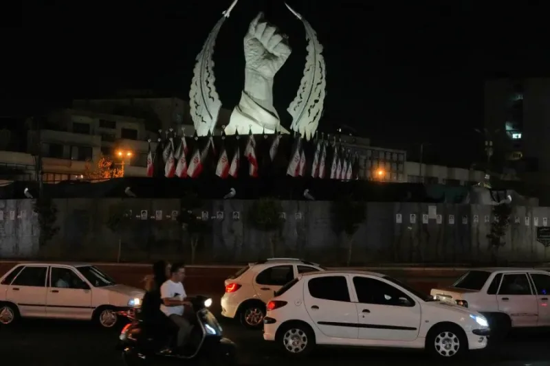 Vehiculos circulan frente a un monumento en Teheran durante la escalada entre Estados Unidos e Iran