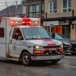 Ambulancia circulando con luces de emergencia en una calle urbana