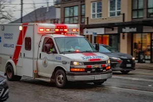 Ambulancia circulando con luces de emergencia en una calle urbana