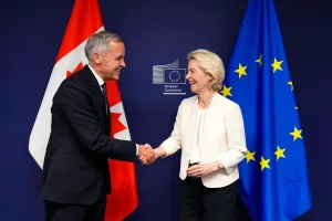 Ursula von der Leyen y Mark Carney frente a las banderas de la Unión Europea y Canadá